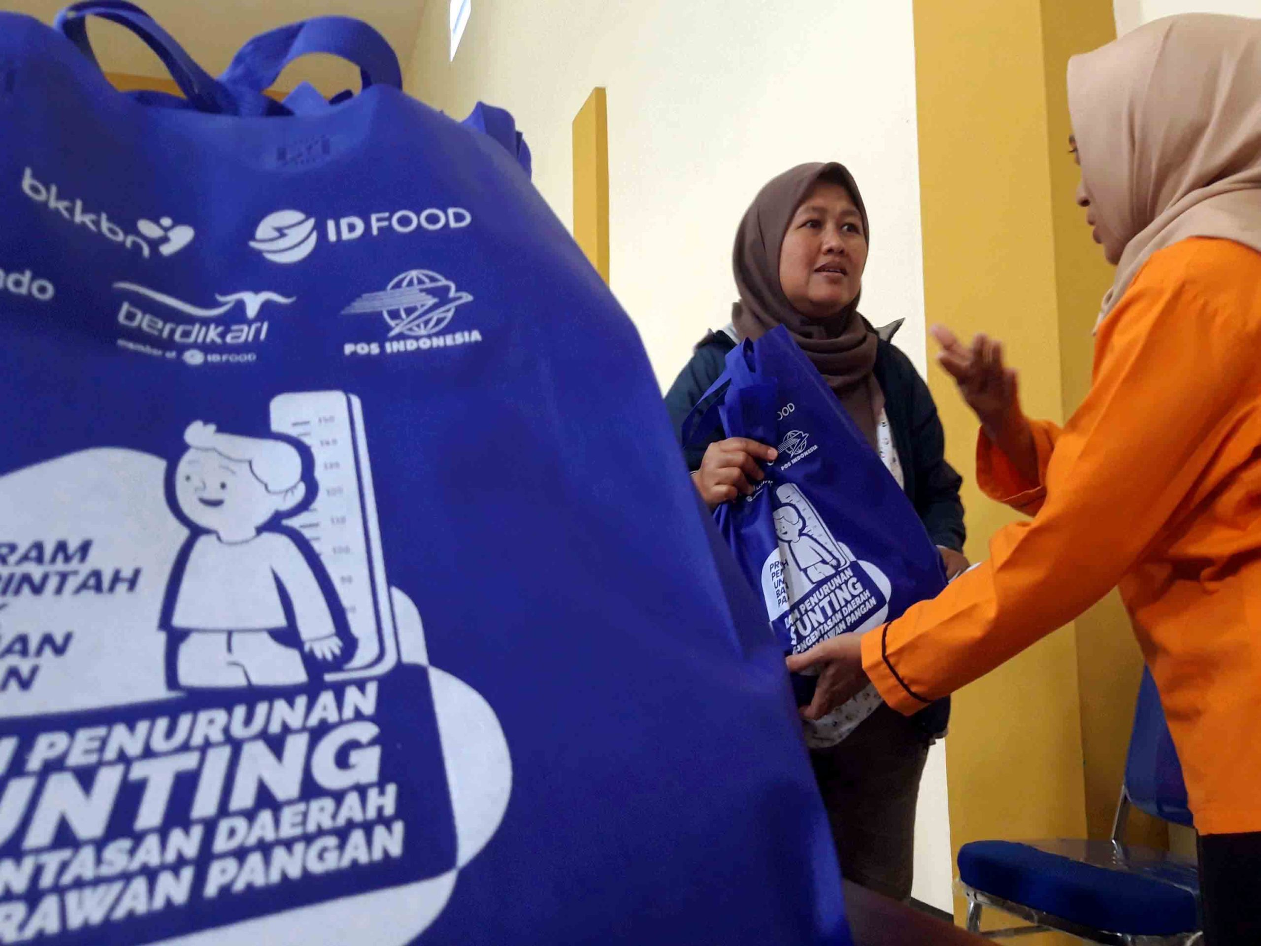 Petugas menyerahkan bantuan pangan
