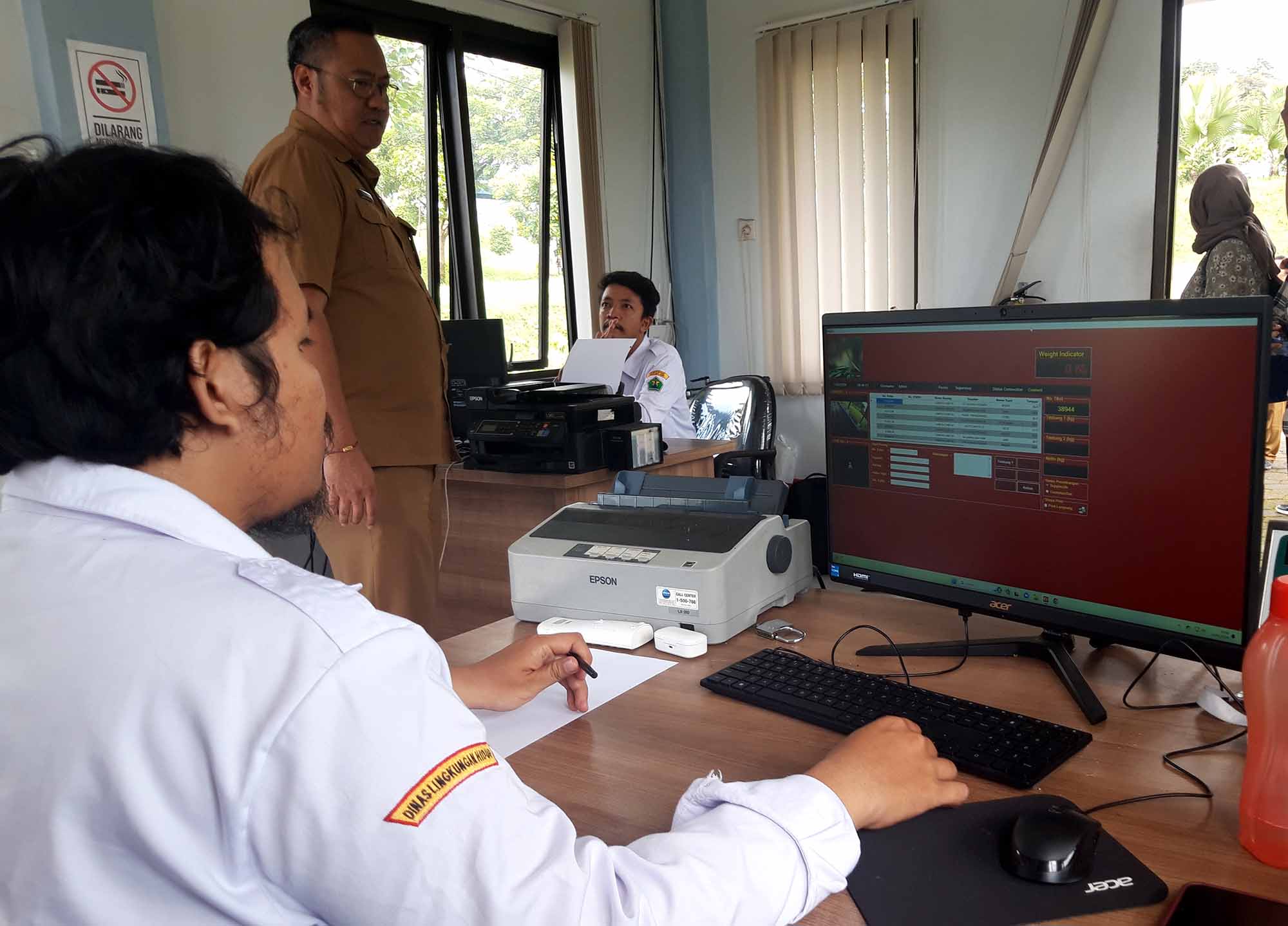 Kepala Dinas Lingkungan Hidup Kota Malang Noer Rahman Wijaya mengecek data truk pengangkut sampah yang masuk jembatan timbang di TPA Supit Urang, Selasa (13/2). Pendataan berbasis komputer mencatat detail nomor polisi truk, asal sampah, nama pemasok, jumlah dan jenis sampah yang diangkut. Foto : Dok. Tugusatu.com