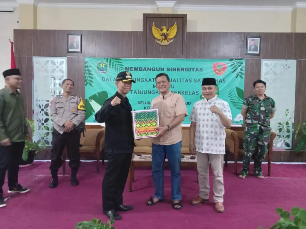 Camat Sukun I. K. Widi E. Wirawan, S.Sos (kiri) dan Lurah Tanjungrejo Mokhamad Dulajis, S.A.P (kanan) menyerahkan bingkisan kepada warga. Foto: Tugusatu/Fajrul Islamy