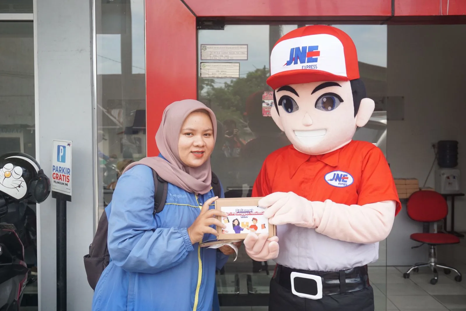 Joni, maskot JNE, membagikan bingkisan spesial Hari Pelanggan untuk pelanggan yang beruntung. Istimewa