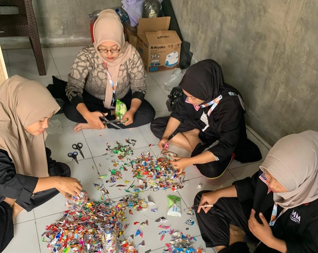 Mahasiswa UMM mengajari warga membuar kursi ecobick dari sampah. Istimewa