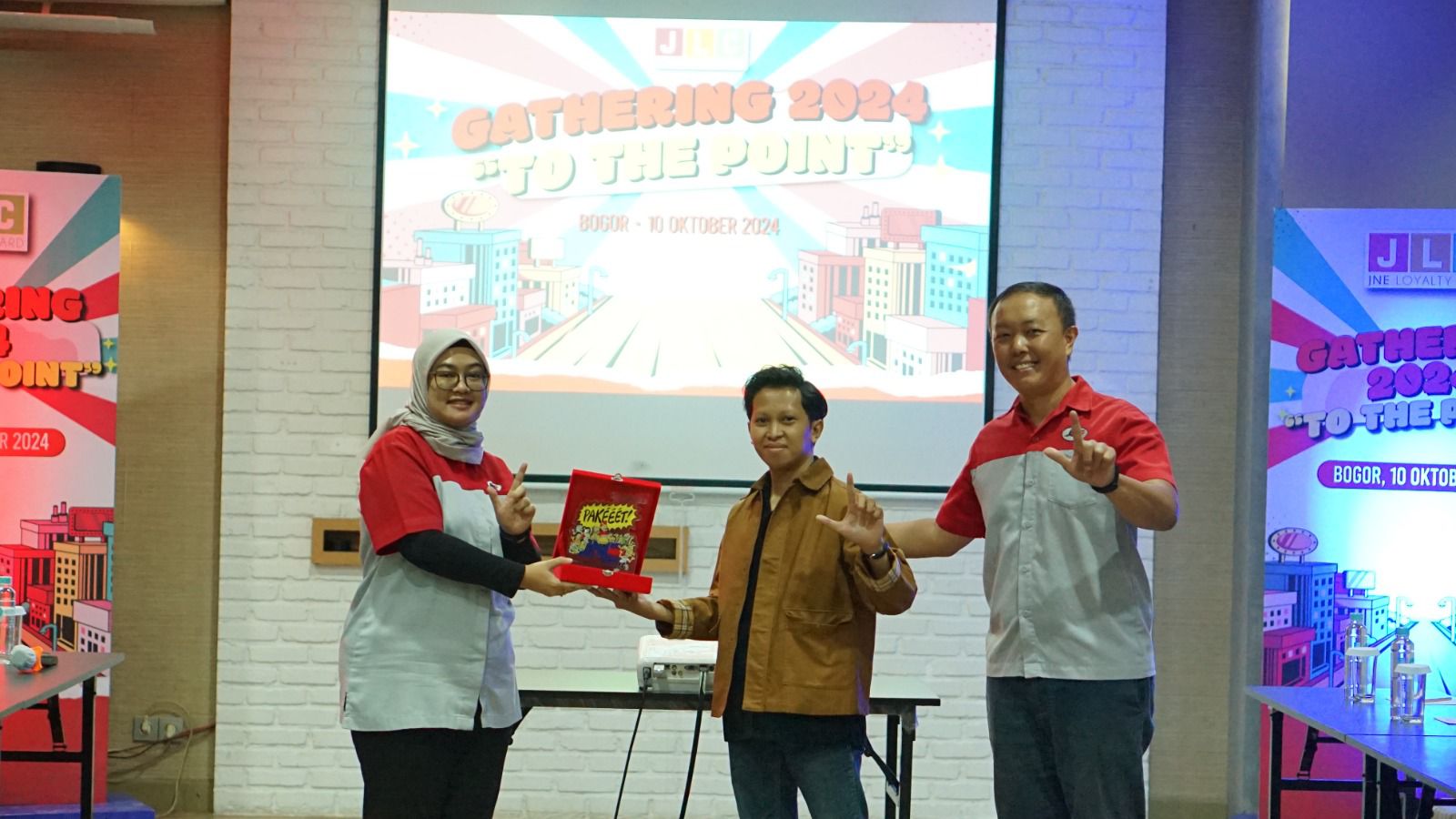 Fanny Elvandari Sahbandar, Customer Loyalty Dept Head JNE (kiri) dan Sebastian, Kepala Cabang JNE Bogor (kanan) menyerahkan  Plakat JNE kepada Muhammad Aditya (dua kiri) sebagai Local Hero Bogor yang telah memaparkan materi dalam JLC Member Gathering 2024. Istimewa