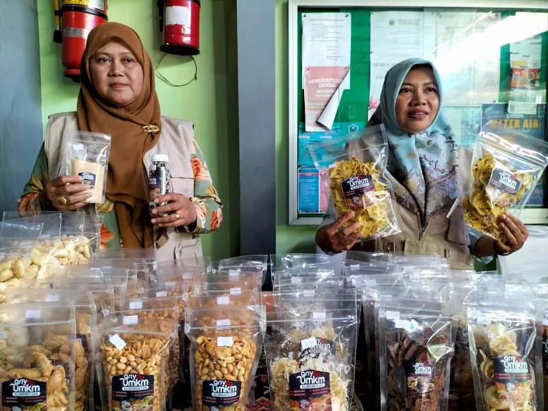 Siti Chalimatus Sakdiyah (kiri) dan Yayuk Mulyati (kanan) menunjukkan produk camilan buatannya di Griya UMKM Kelurahan Klojen, Kota Malang, Jawa Timur, Kamis (10/10). Foto: Tugusatu/Bagus Suryo