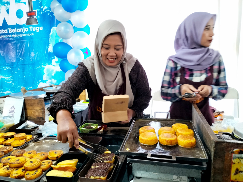 Latifa, pelaku UMKM kue lumpur dan kue pukis melayani pembeli, Selasa (22/10). Ia menikmati berkah sertifikat halal. Foto: Tugusatu/Bagus Suryo