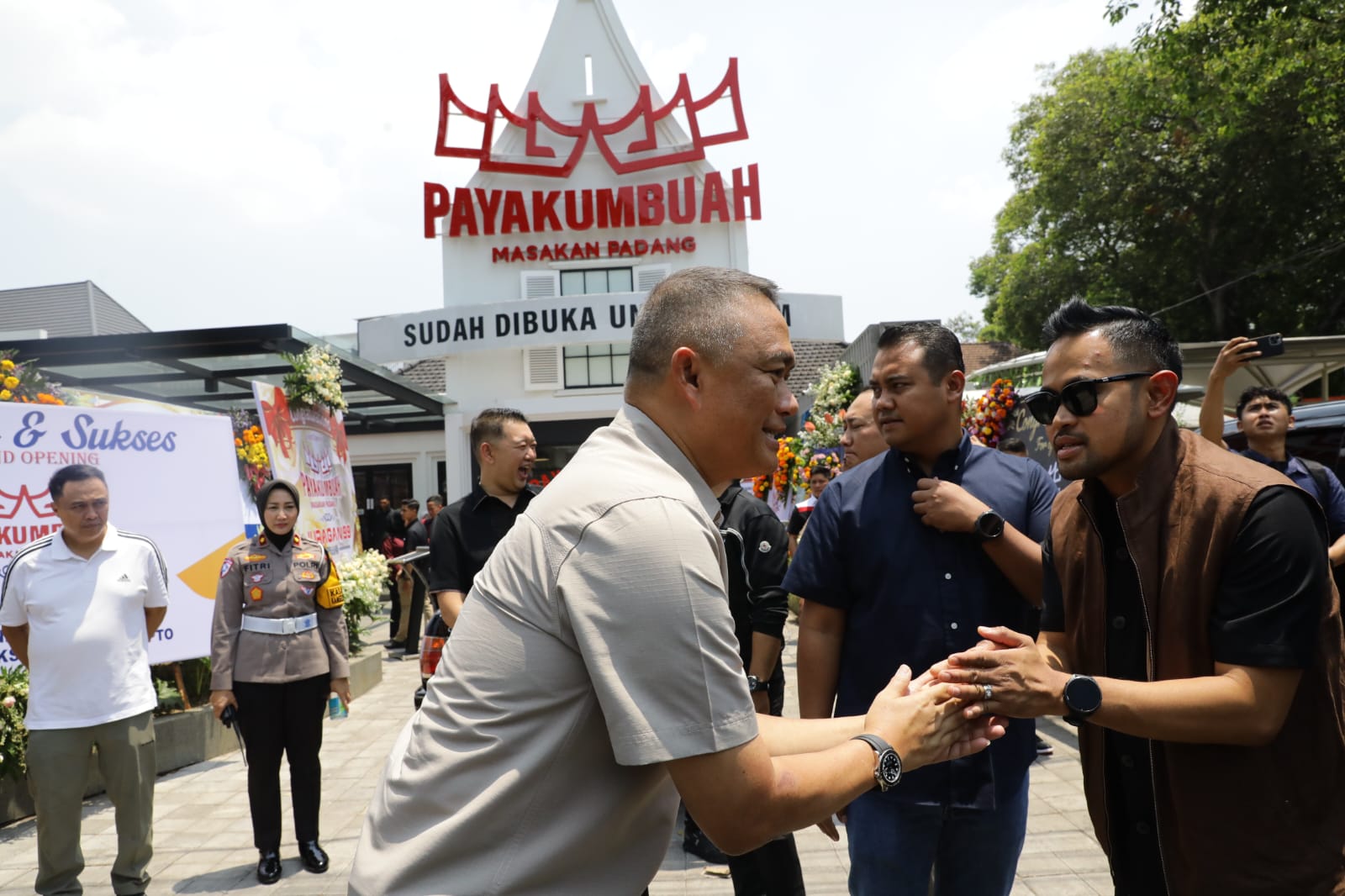 Kapolda Jatim, Irjen Pol. Drs. Imam Sugianto, M.Si (kiri) memberikan selamat pada pemilik RM Padang Payakumnbuah,  Gilang Widya Pramana, pada grand openting rumah makan tersebut, Minggu (13/10/2024). Istimewa