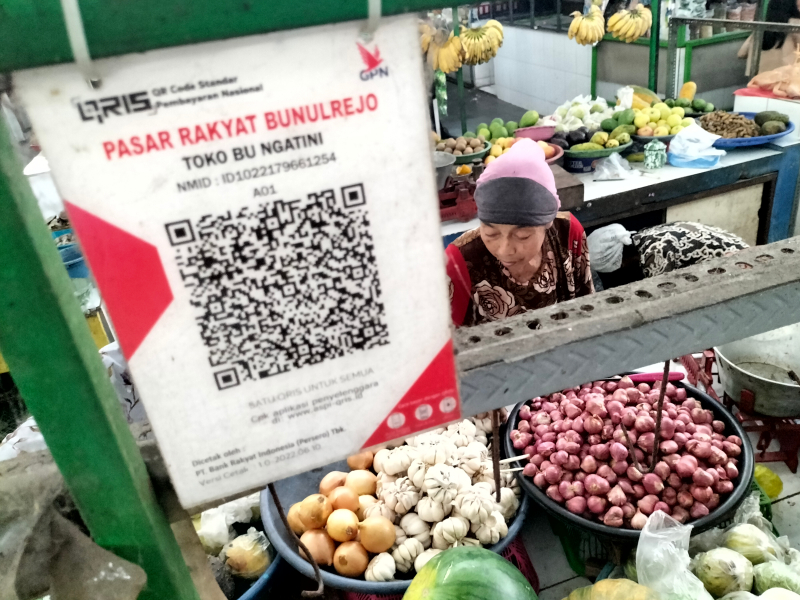 Pedagang di Pasar Bunulrejo menggunakan QRIS untuk transaksi nontunai. QRIS sudah diterapkan di semua pasar di Kota Malang. Foto: Tugusatu/Bagus Suryo