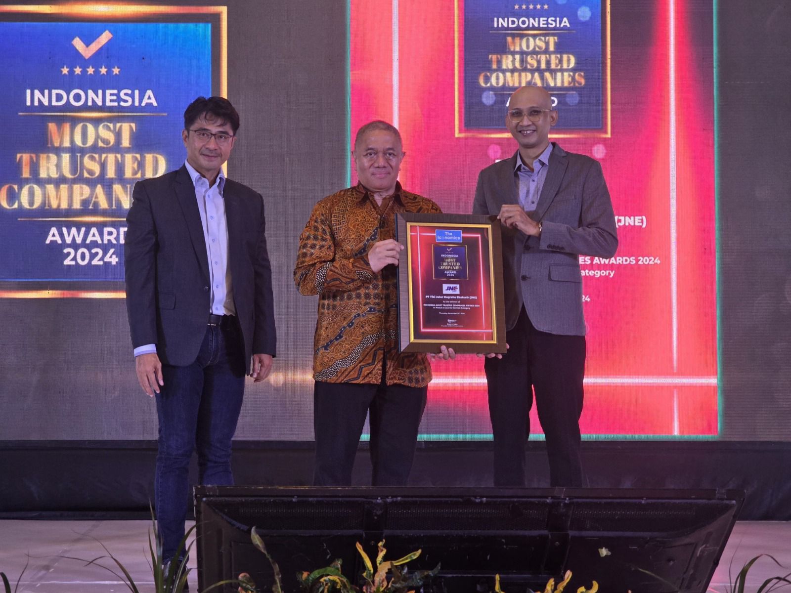 Feriadi Soeprapto, Presiden Direktur JNE (tengah) menerima penghargaan dari Indonesia Most Trusted Companies Award 2024 yang diberikan oleh Arif Hatta selaku Pimpinan Redaksi The Iconomics (dari kanan) dan Alex Mulya selaku Director of Research & Brand Strategy The Iconomics di Royal Kuningan Jakarta, Kamis (21/11/2024). Istimewa
