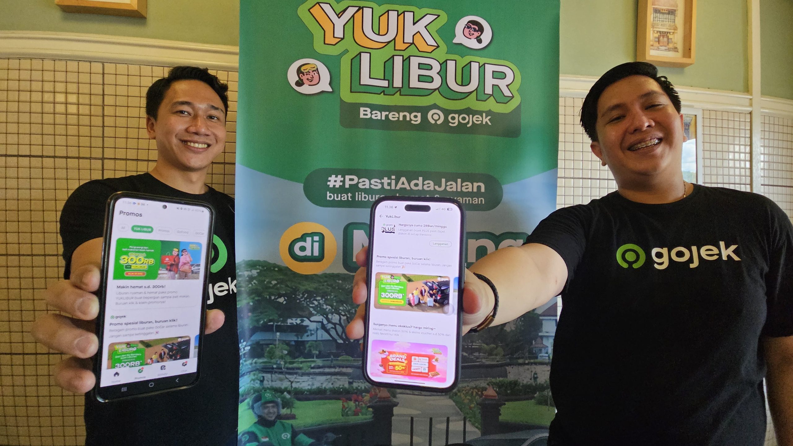 Head of Corporate Affairs Gojek wilayah Jawa Timur, Bali, Nusa Tenggara, Armyn Gita (kiri) bersama Area Head Gojek Malang, Achriansyah Agung, menunjukkan program YUK LIBUR di gadgetnya, Kamis (19/12/2024). Istimewa
