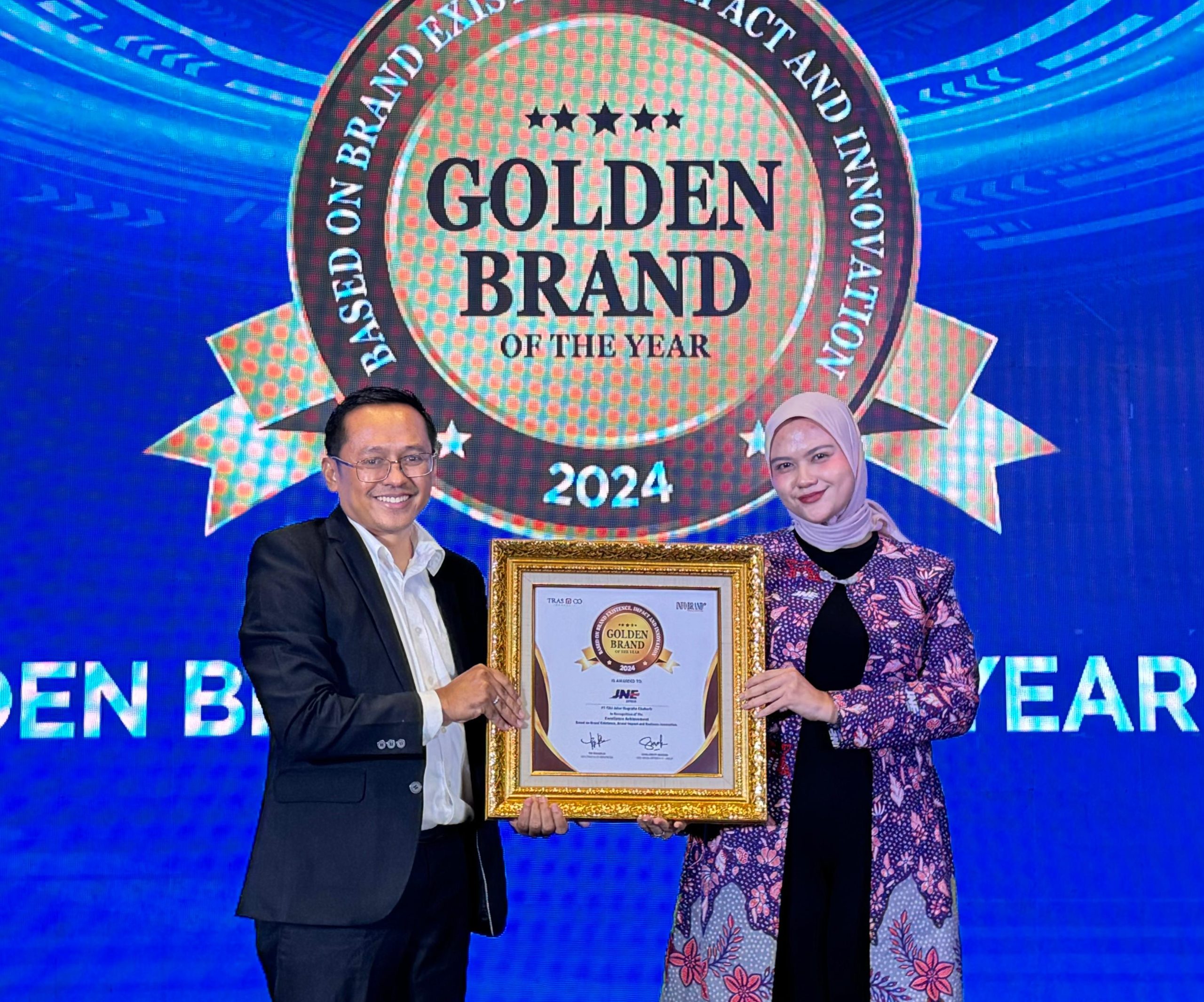 Nadya Dharmawati Puteri, Digital Media Section Head JNE mewakili penerimaan penghargaan Golden Brand of The Year 2024, yang diserahkan Tri Raharjo, CEO Tras N Co Indonesia, Kamis (19/12/2024) lalu. Istimewa