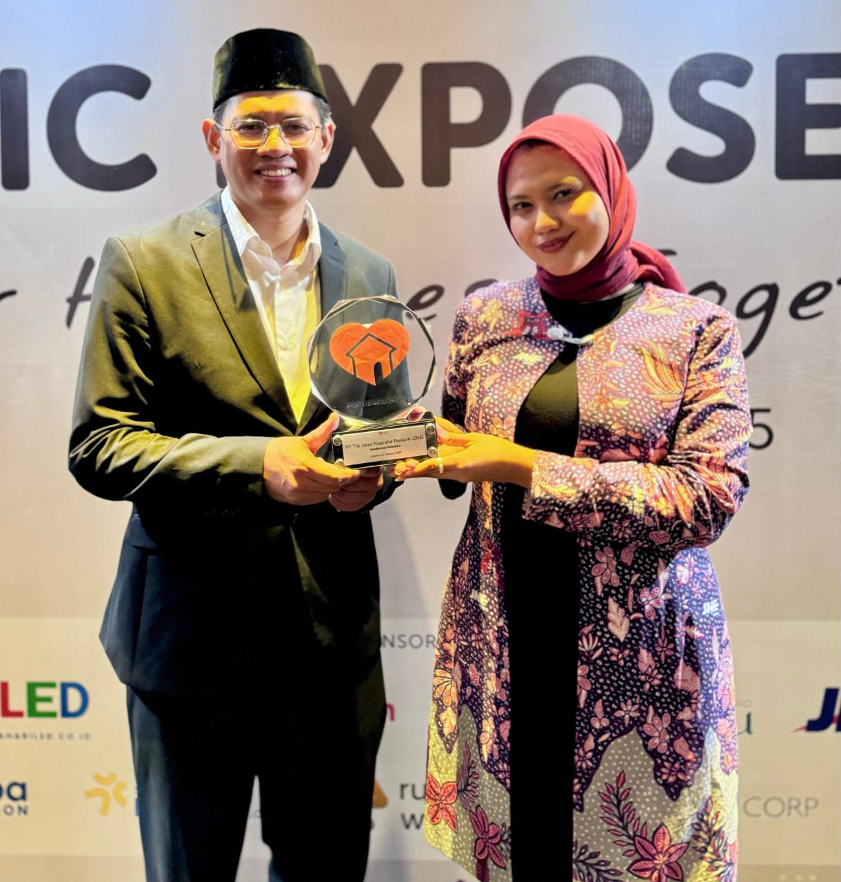 Irvan Nugraha, CEO Rumah Zakat, menyerahkan penghargaan kepada perwakilan JNE Nadya Dharmawati Puteri selaku Digital Media Section Head Penghargaan di Pullman Jakarta Indonesia, Kamis (13/2/2025). Istimewa