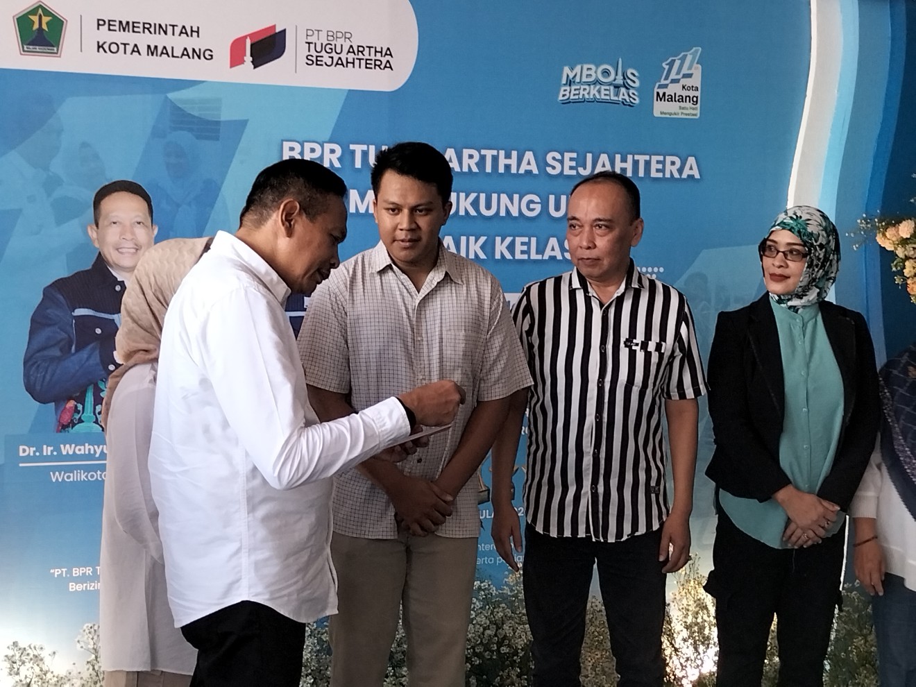 Wali Kota Malang Wahyu Hidayat memberikan buku tabungan PT BPR Tugu Artha Sejahtera kepada pelaku UMKM. Foto: Tugusatu/Bagus Suryo