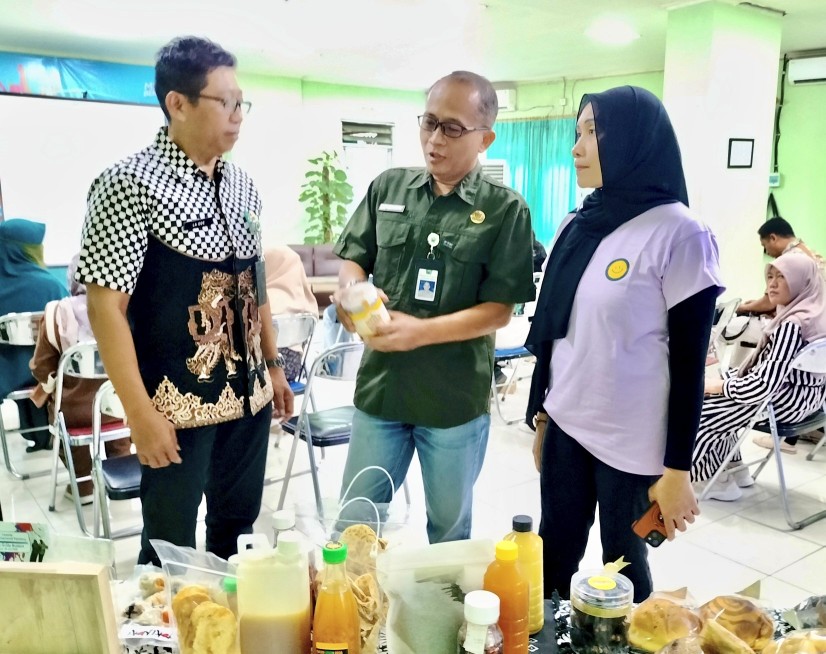 Sekretaris Disporapar Kota Malang Wahyu Setiawan (tengah) dan Kepala Bidang Pemasaran Pariwisata dan Ekraf Disporapar Laode Al Fitra (kiri) melihat logo dan merek milik pelaku ekraf. Foto: Tugusatu/Bagus Suryo