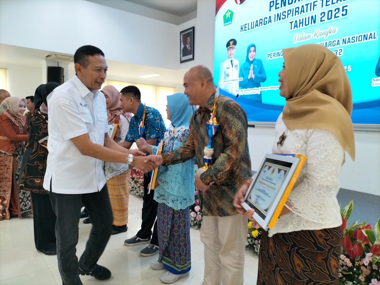 Wali Kota Malang Wahyu Hidayat menyalami penerima anugerah Keluarga Inspiratif Teladan KB Lestari. Foto: Tugusatu/Bagus Suryo