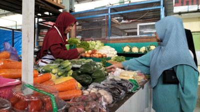Pedagang sayur di Pasar Bunulrejo, Kota Malang, melayani pembeli. Foto: Tugusatu/Bagus Suryo
