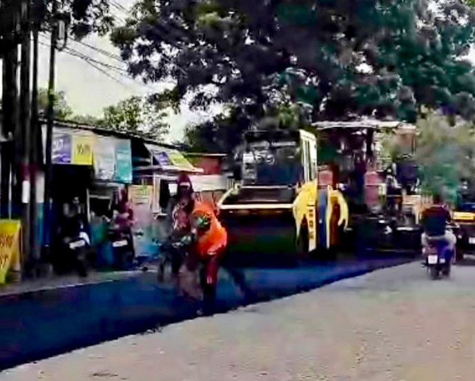 Pekerja mempercepat perbaikan jalan dalam program prioritas Jalan Mantap dan Alus Lamongan (Jamula). Foto: Tugusatu/Ahmad Yakub/ist