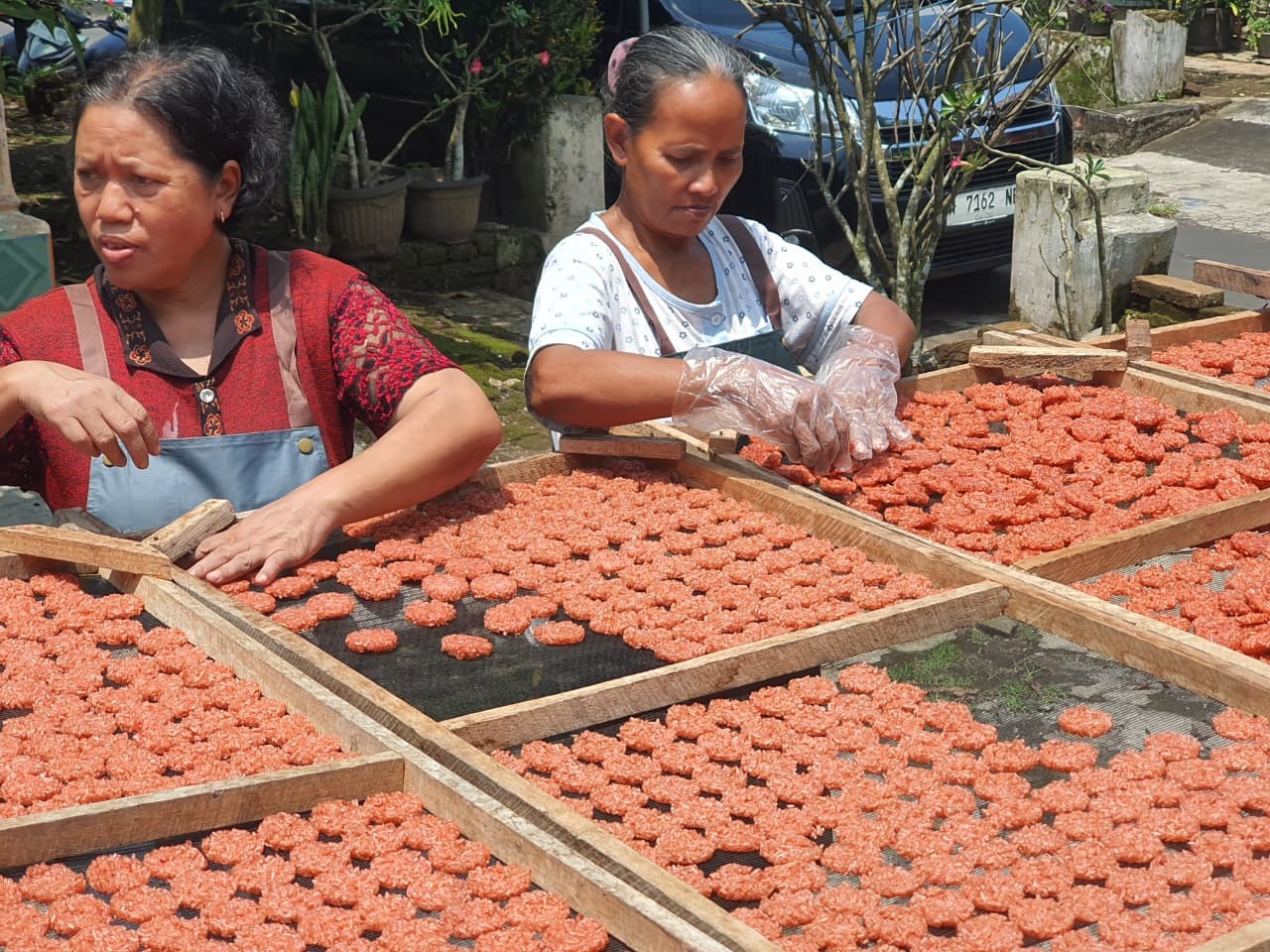 Karyawan Rengginang Kencana tengah membalik rengginang yang tengah dijemur