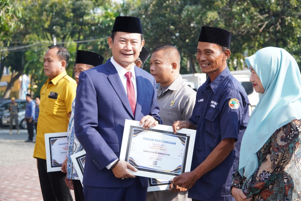 Bupati Lamongan Yuhronur Efendi menyerahkan piagam penghargaan saat Hari Koperasi. Foto: Tugusatu/Ahmad Yakub/ist